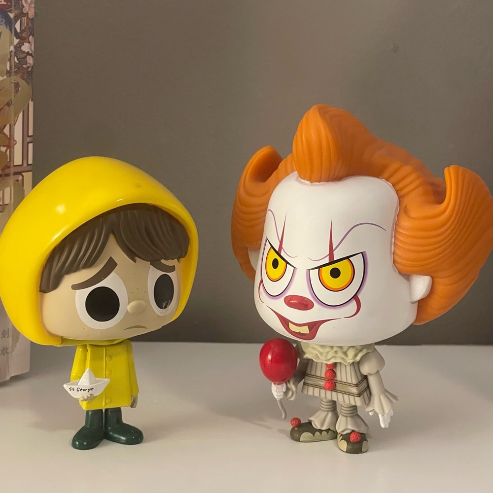 Funko Pennywise and Georgie Figures with Yellow and Orange Accents